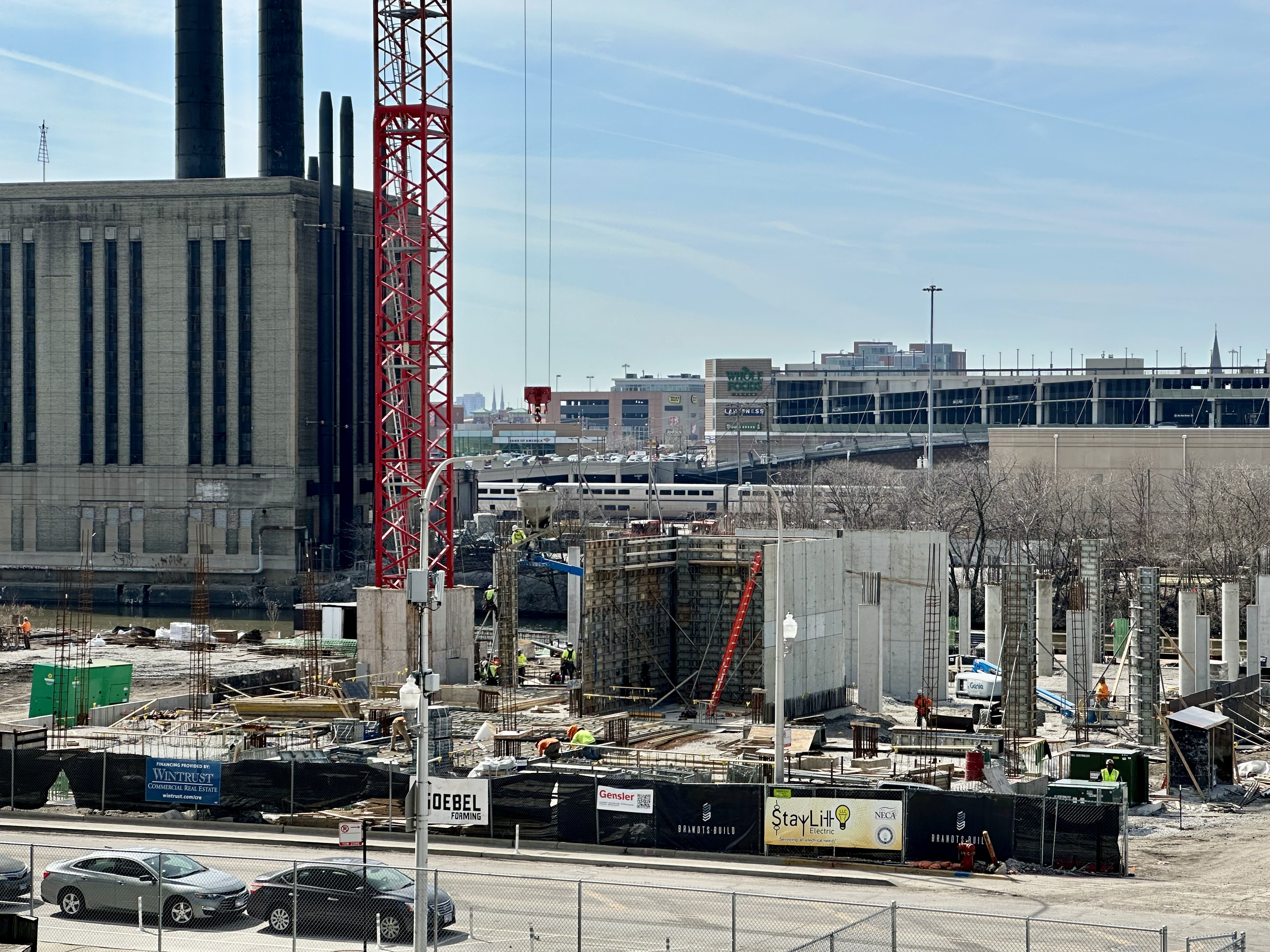 a residential building at 1010 S Wells St is under construction, and there's a red tower crane lifting a concrete bucket